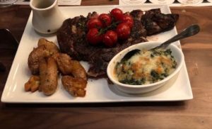 A 25 oz, bone-in rib eye with blistered tomatoes, crispy potatoes, spinach gratin/butternut squash at Cooper's Hawk Esquire Chicago. (J Jacobs photo)